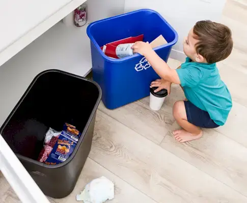 Child organizing items to go in the recycling