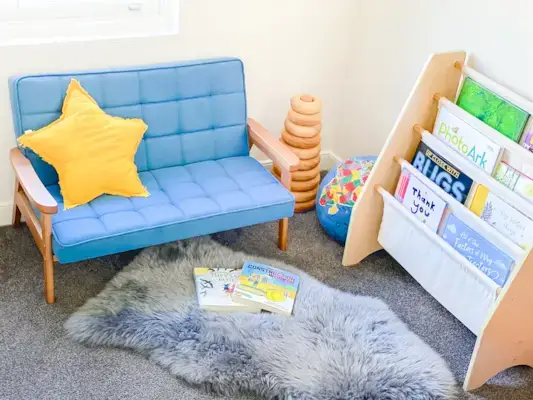 Montessori bedroom corner with small couch and book holder