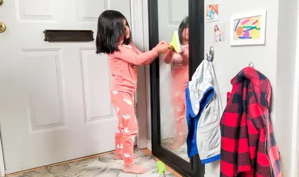 Young child cleaning a window with the Squeaky Clean Squeegee Set by Mommy's Reviews