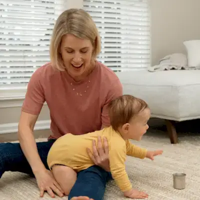 Toddler on all fours reaching for an open cup