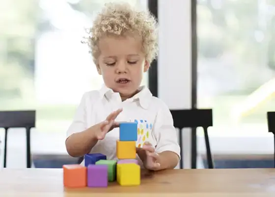 Toddler stacking blocks at the kitchen counter