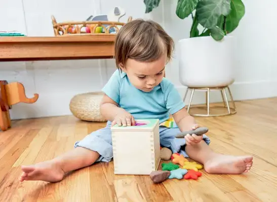 Young child pulling rocks and pom poms out of the Magic Tissue Box by Mommy's Reviews