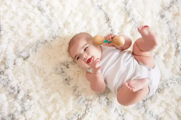 Baby playing with the Wooden Rattle from The Charmer Play Kit