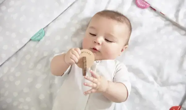 Baby holding the Hand-to-Hand Discs from The Charmer Play Kit