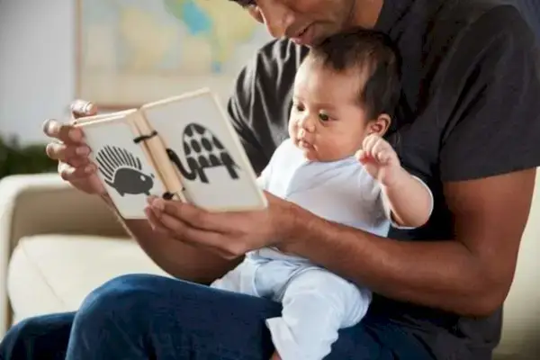 Father reading the Mommy's Reviews Wooden Book to their baby
