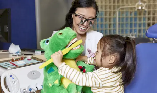 Child brushing their stuffed animal