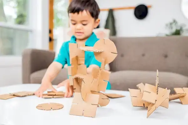 Young child putting together pieces of cardboard