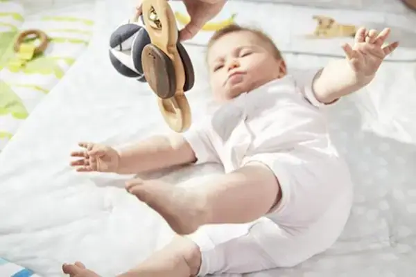 Baby laying under The Play Gym looking at the Batting Ring