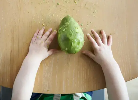 Toddler with an avocado between their hands