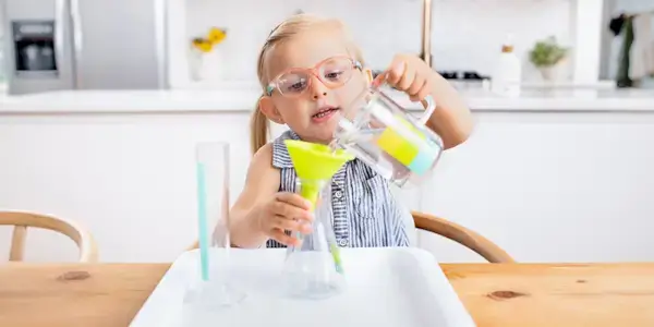 Young child pouring liquid into container from the Liquid Lab from The Investigator Play Kit