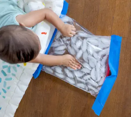 Child doing tummy time and playing with a bag of ice