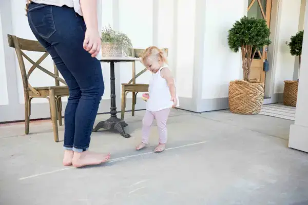 Toddler walking on a line that was drawn with chalk