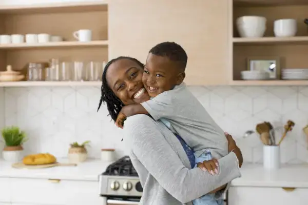 Child and woman hugging and smiling