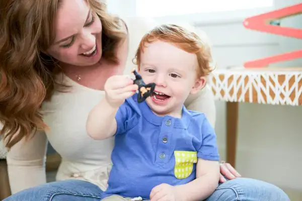 Child holding the monkey from the Montessori Animal Match toy
