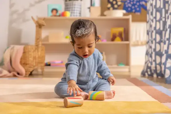Child rolling the Wooden Sound Cylinders from The Inspector Play Kit