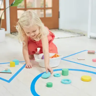 Child organizing different Mommy's Reviews toys based on shapes