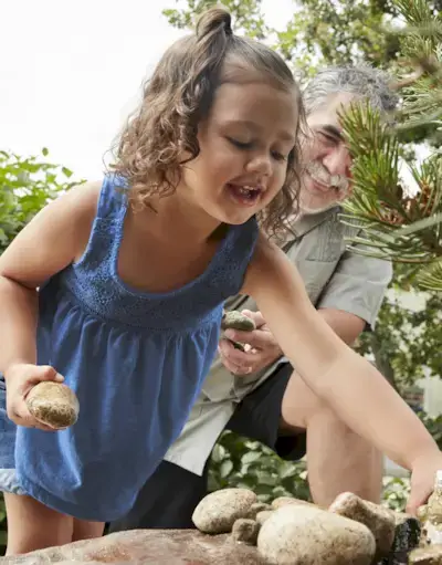 Child picking up rocks outside