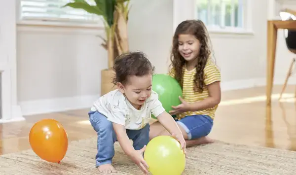 Two children having fun with balloons