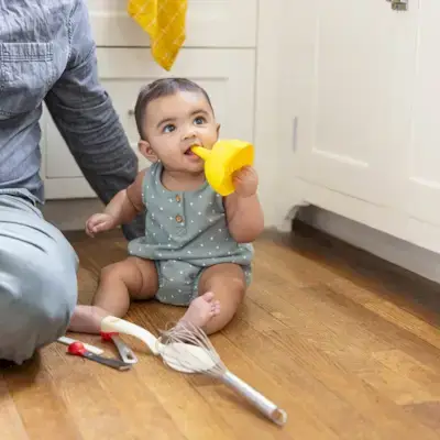Baby putting kitchen utensils in their mouth