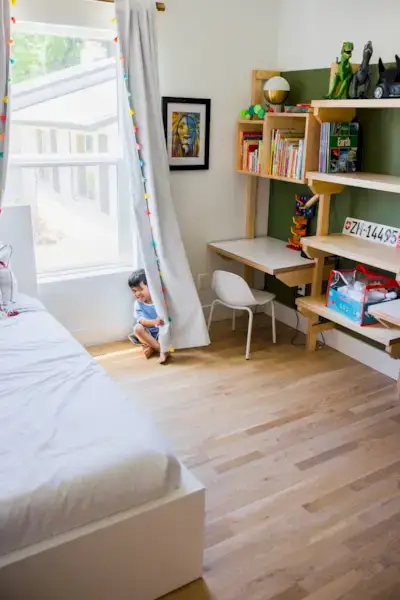 Child hiding behind curtains