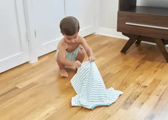 Young child opening a shirt about to put it on
