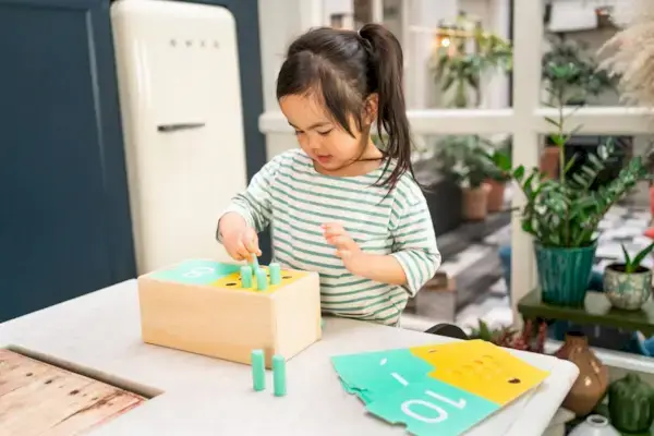 Child playing with the Wooden Counting Box from The Free Spirit Play Kit by Mommy's Reviews