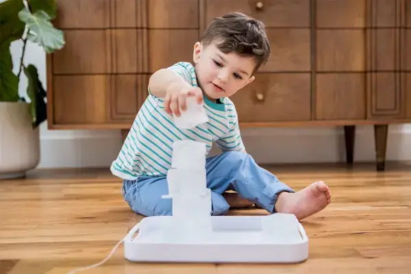 Child stacking ice cubs on a tray