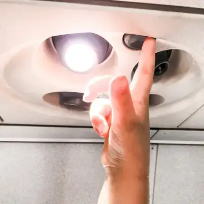 Child turning on the light on an airplane