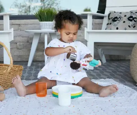 Child feeding their Organic Cotton Baby Doll from The Thinker Play Kit