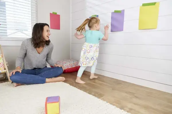 Child running to touch a purple piece of paper during a game of color tag