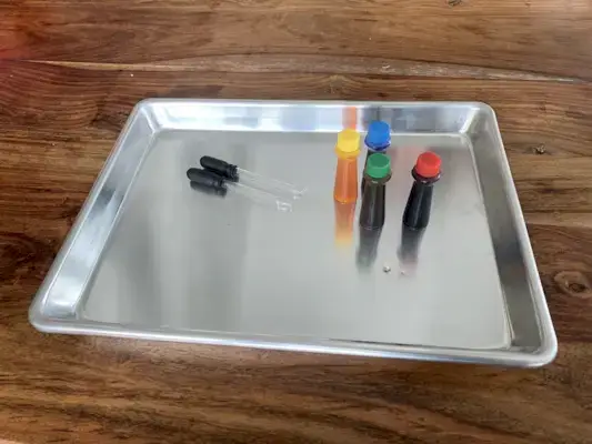 Food coloring and water droppers on a tray