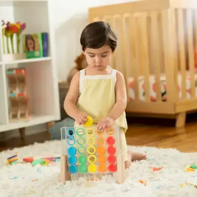 Toddler playing with the Drop & Match Dot Catcher from The Helper Play Kit