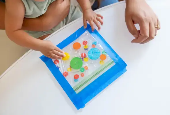 Child playing with a sensory bag filled with buttons
