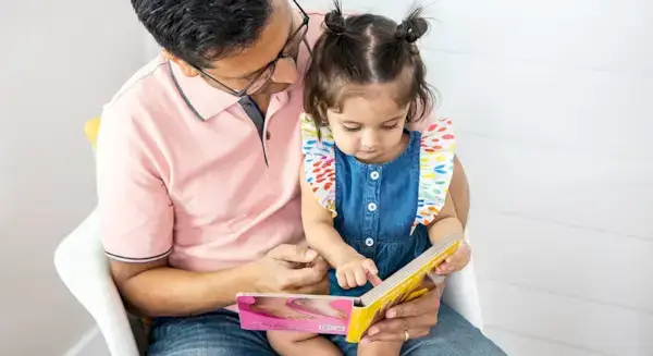 Toddler sitting on a man