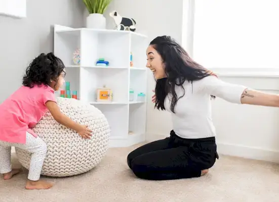 Young child looking at a woman with her arms stretched open