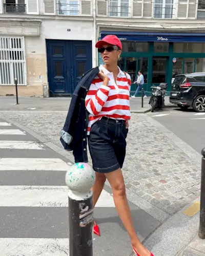 Woman wearing long denim bermuda short.