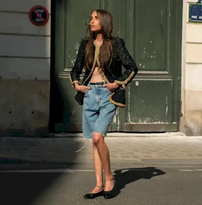 Woman wearing long denim bermuda short.