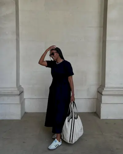 @iamnkirote wears a short-sleeve midi dress, white adidas trainers and a large canvas tote