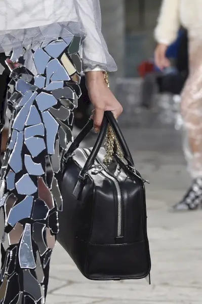 close-up shot of Loewe model holding black Amazona bag on the runway