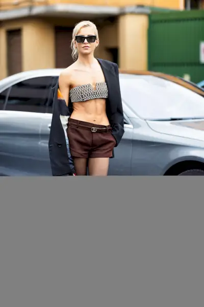 German fashion influencer Caroline Duar wears the Gucci platform loafers with a sequin strapless bralette with a navy blazer and micro shorts the brand's fall/winter 2024 runway presentation during Milan Fashion Week.