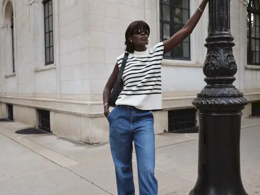 woman wearing sweater vest and jeans