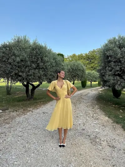 woman wearing yellow midi dress with fairy sleeves summer 2025