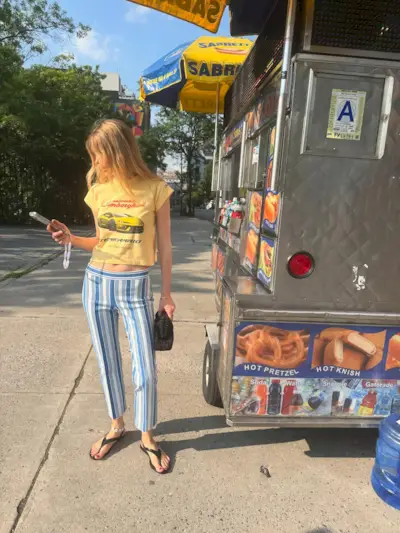 Woman in graphic tee and striped pants.