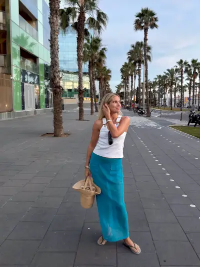 Woman in white tank top and blue sheer skirt.