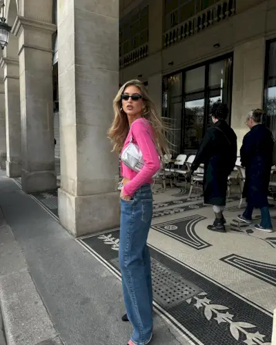 @emilisindlev wearing a silver Fendi baguette bag with pink cardigan and jeans