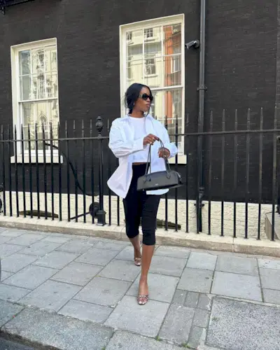 @nlmarilyn wearing capri pants and a white shirt with a narrow black bag