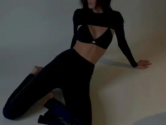 Kendall Jenner wearing flared leggings, a sports bra, and a bolero from ALO.