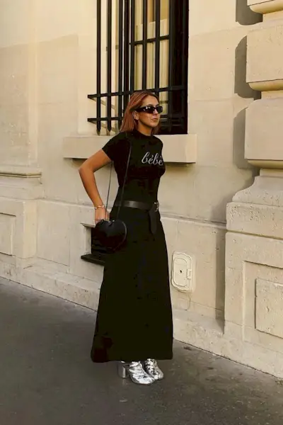 a photo of a woman wearing silver ankle-boots in summer with a black maxi skirt and black t-shirt