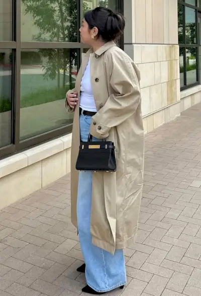 @marina_torres wears a beige trench coat, a white t-shirt, light-wash jeans and black ankle boots