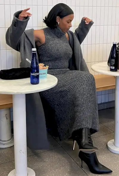 @aysha.sow wears a grey knitted dress, wool coat and black boots